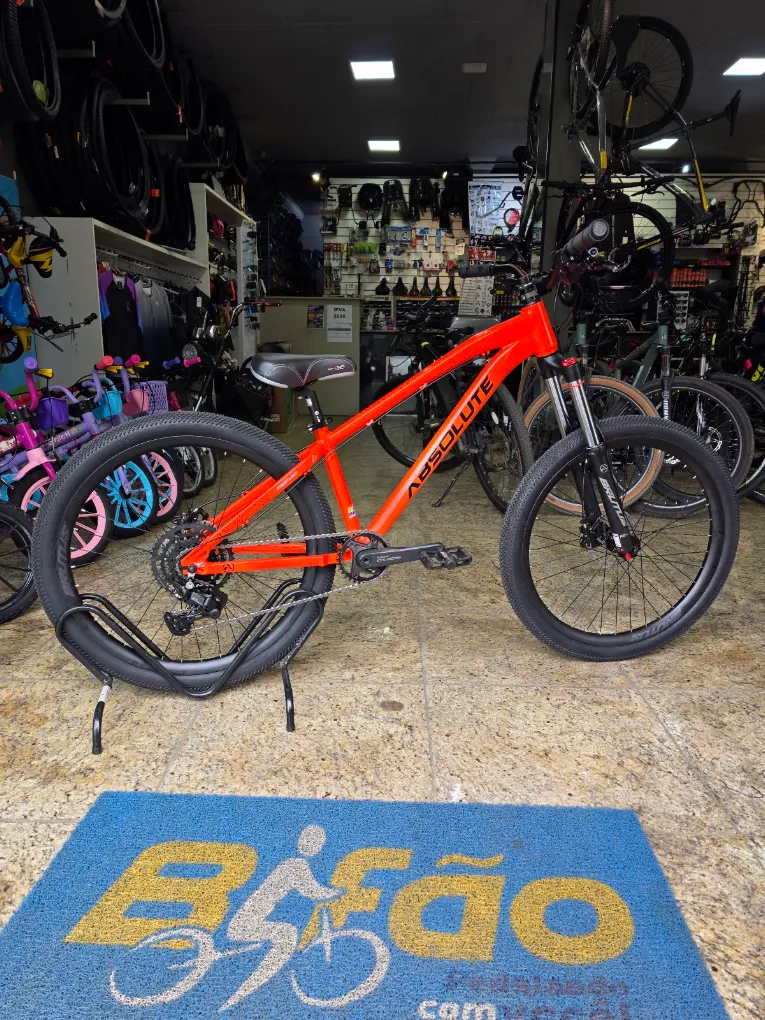 Bicicleta Absolute laranja sobre o tapete Bifão